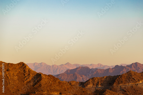 Sunset over Jabal Haqamah pick in Fujairah mountains. Concept of calm and serenity. Concept of wild and dangerous tourism.