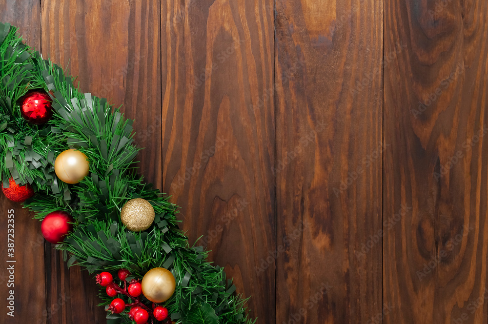 Christmas or New Year decoration background: pine branches, colorful glass balls on the dark, rustic wooden background and with space for text. Minimalist background. Top View Christmas or New Year decoration background: pine branches, colorful glass balls on the dark, rustic wooden background and with space for text. Minimalist background. Top View