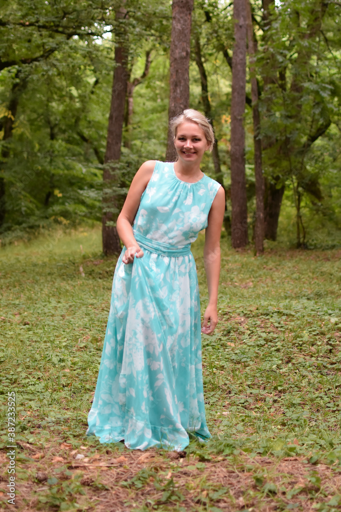 beautiful lady walks in the forest alone, a woman in a long light dress i