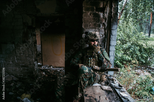 Soldier talking on the walkie-talkie inside the building, military concept © romankosolapov