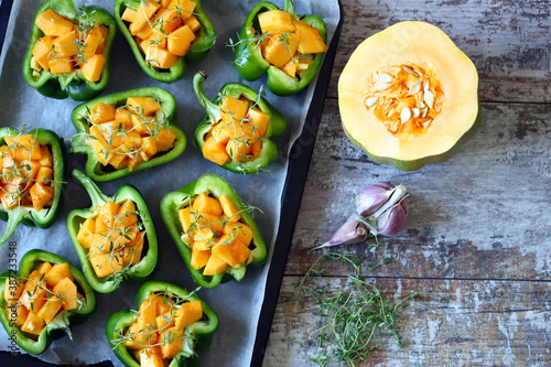 Selective focus. Green peppers stuffed with pumpkin pieces. Autumn dishes. Healthy food. Vegan lunch.