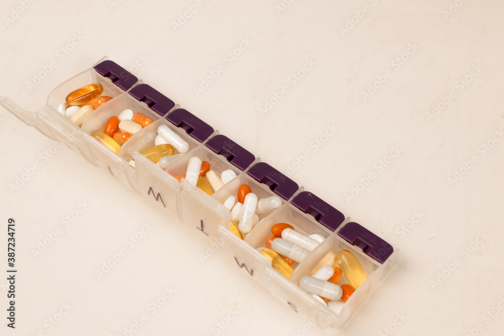 Daily pill box full of vitamins and medications and supplements Daily pill box full of vitamins and medications and supplements