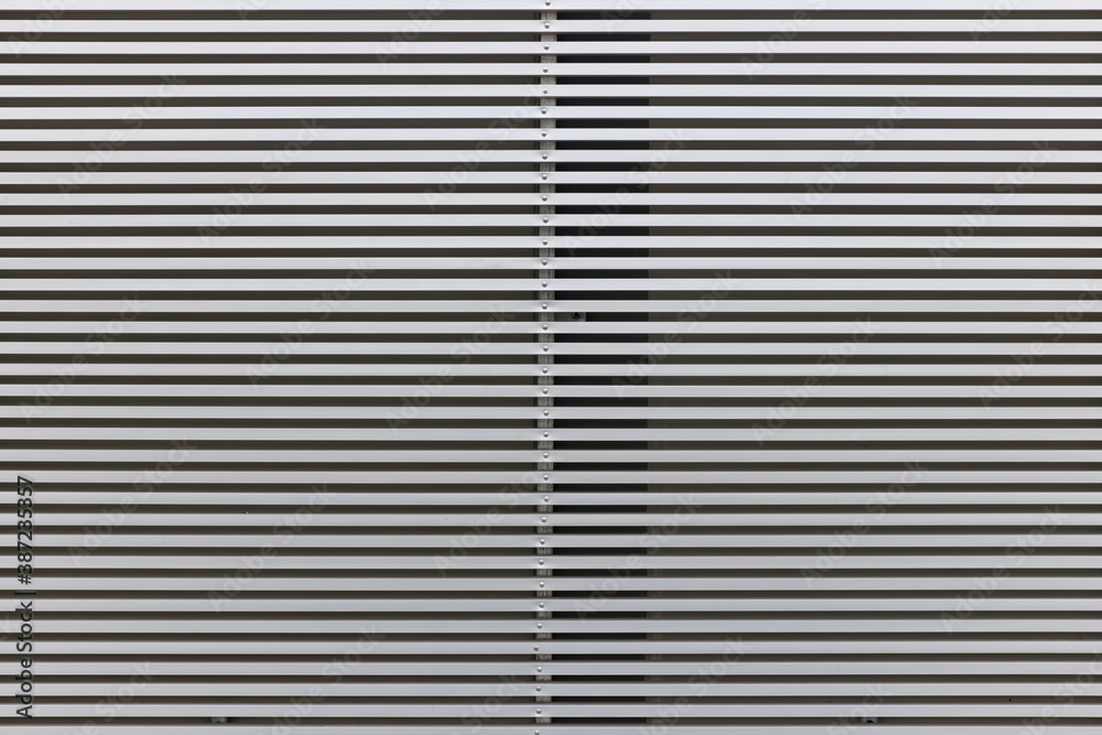 Metal Bars as a Background. Texture of ventilation grille for air intake in office building. Jalousie. Background. Stripes Metal Bars as a Background. Texture of ventilation grille for air intake in office building. Jalousie. Background. Stripes