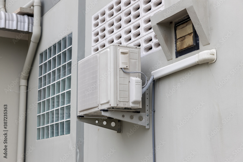 Air conditioner compressor installed in old building. Outdoor split ...