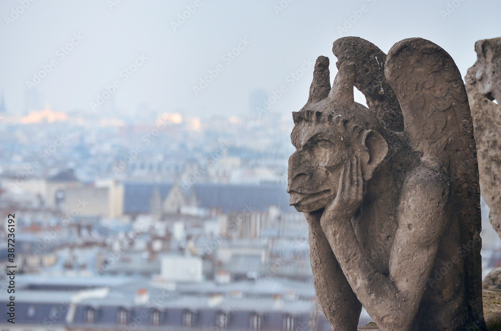 A gargoyle watching Paris city landscape in Notre Dame