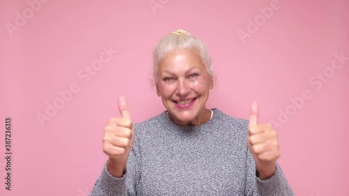 Happy elderly woman holding her thumb up