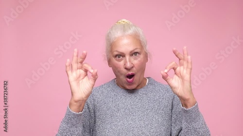 Smiling senior lady gesturing perfect ok gesture.