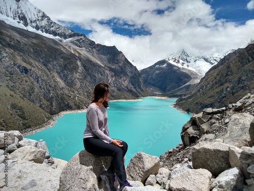 Girl at Laguna Paron, Huaraz, Peru. A blue-green lake in the Cordillera Blanca on the Peruvian Andes. At 4185 meters above sea level, it's surrounded by snowy peaks and a pyramid mountain.  © Agata