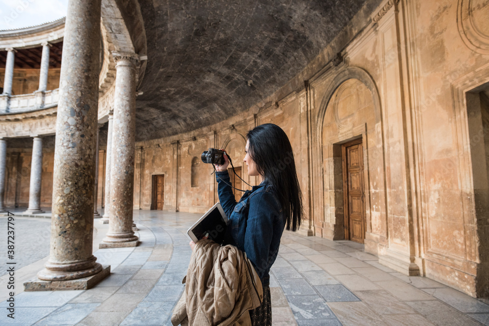 Tourist young woman in Carlos V palace, in 