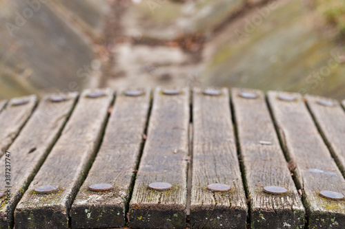 Old wooden boards of a bridge with round iron rivets.