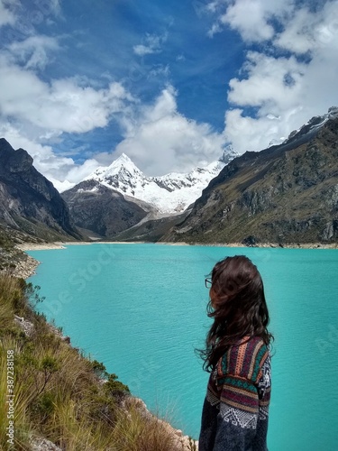 Girl at Laguna Paron, Huaraz, Peru. A blue-green lake in the Cordillera Blanca on the Peruvian Andes. At 4185 meters above sea level, it's surrounded by snowy peaks and a pyramid mountain. 