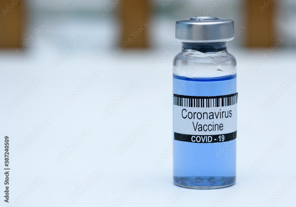 Coronavirus vaccine in bottle for injection on table against background medical laboratory. Defeating SARS-CoV-2 coronavirus epidemic. Scientists have found vaccine against coronavirus