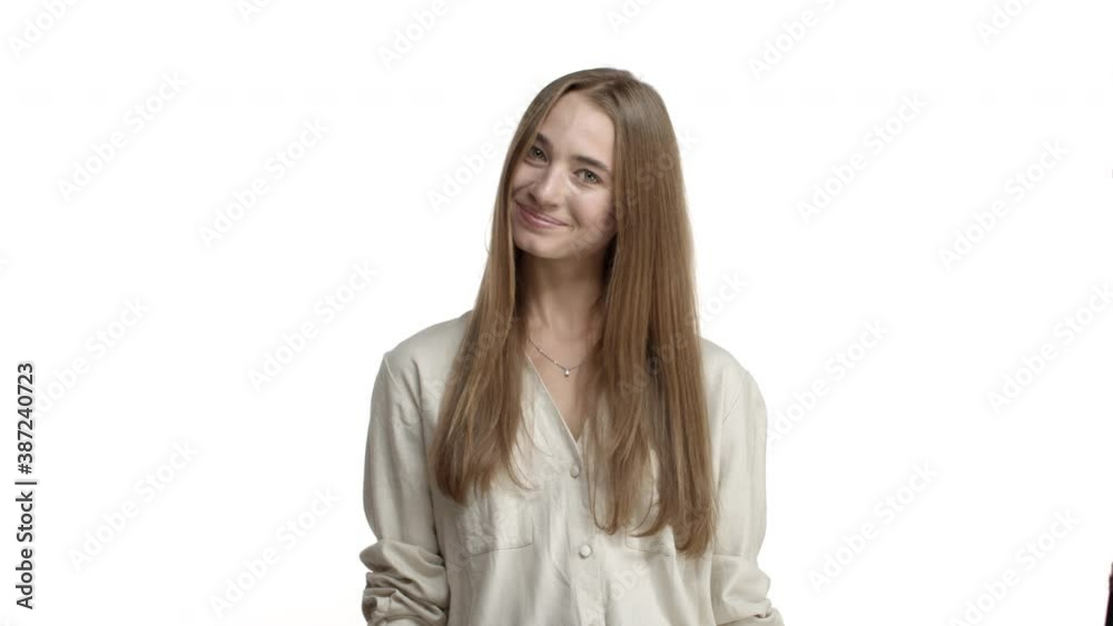 Young pretty woman with long fair hair and braces on teeth, smiling and asking to come closer, luring you, standing coquettish over white background Young pretty woman with long fair hair and braces on teeth, smiling and asking to come closer, luring you, standing coquettish over white background