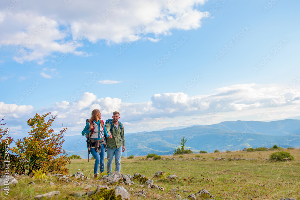 Happy couple hiking and enjoying a valley view