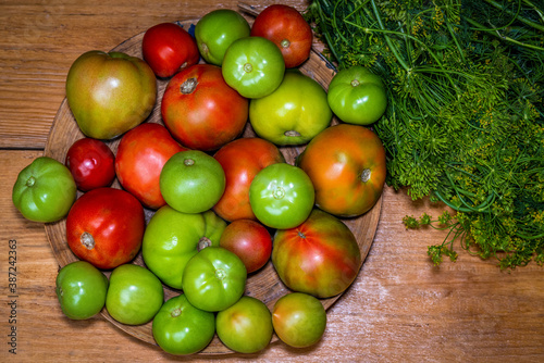 Organic green, red, yellow, orange tomatoes on wooden table