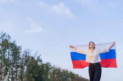 Portrait of a Russian beautiful woman with the national flag. Symbol of the Russian Federation © Artem