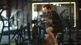 Eager sport man training on exercycle at gym. Fit man doing cardio in sport club