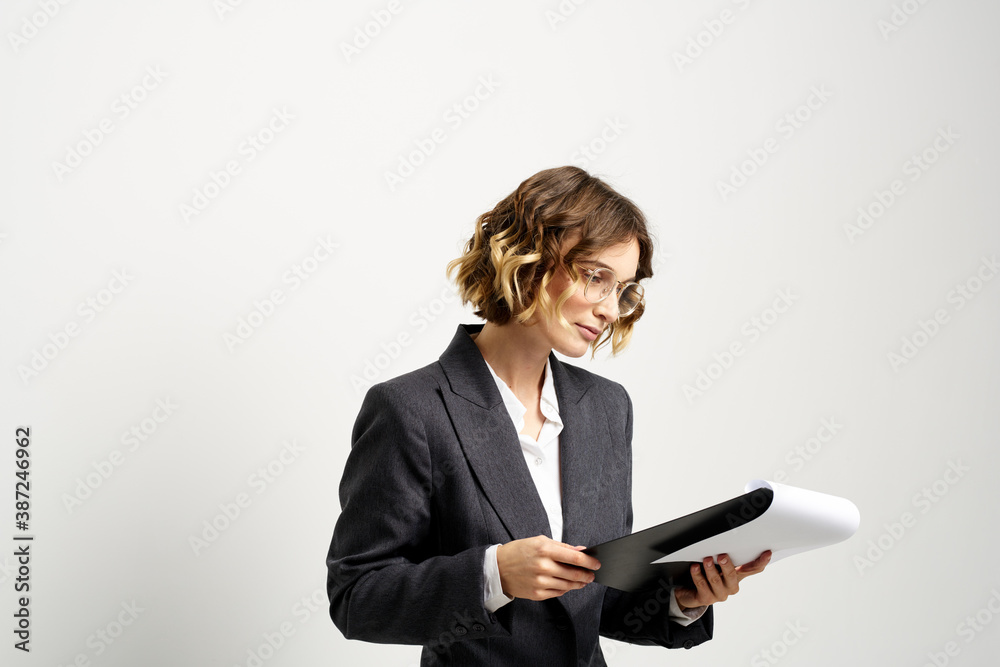 business woman in a suit with documents in hands light background curly hair hairstyle business woman in a suit with documents in hands light background curly hair hairstyle