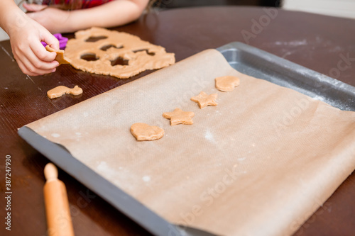 Two little girls cook at home in the kitchen ginger cookies for Christmas