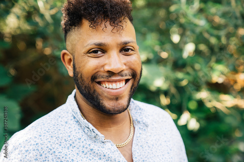 Fotografía Portrait of black man with mohawk standing outdoors in garden laughing