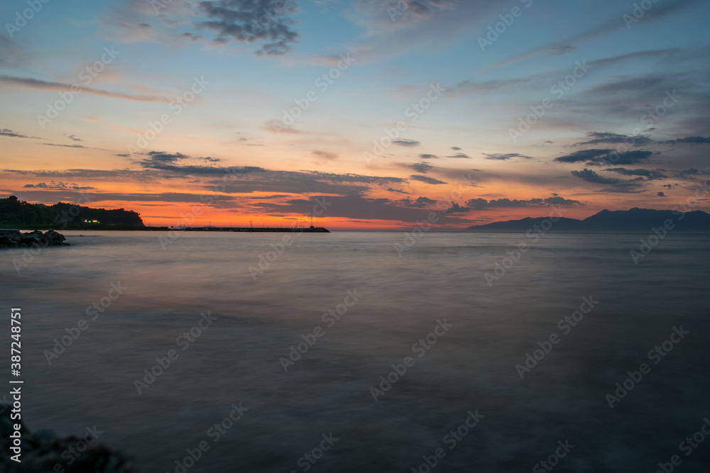 A silhouette of Albanian mountains on the horizon during sunset in Astrakeri, Corfu Island, Greece