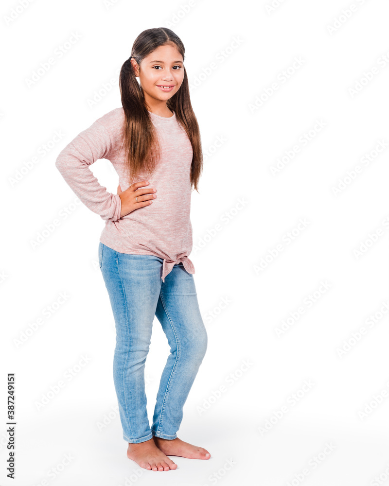 Happy cute smiling casual girl 8-10 years old standing against white background, pink long-sleeve blouse and blue jeans; Hispanic, long brown hair; full-length Happy cute smiling casual girl 8-10 years old standing against white background, pink long-sleeve blouse and blue jeans; Hispanic, long brown hair; full-length