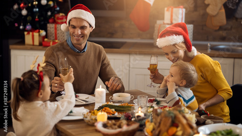 Happy family toasting during Christmas lunch at dining table.