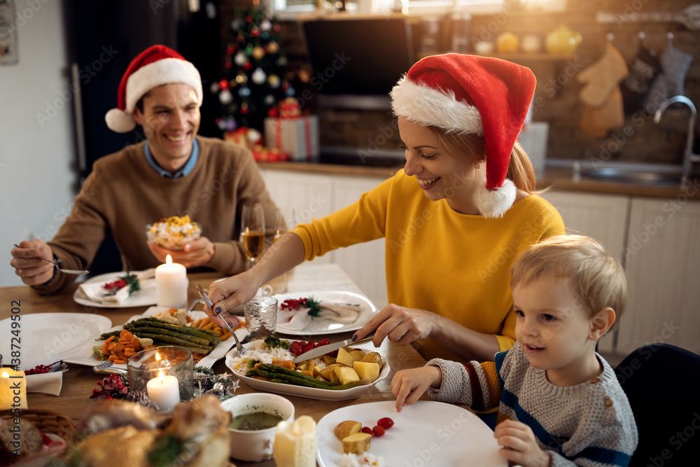 Happy woman enjoying in family lunch at dining table on Christmas day.