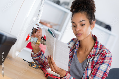 woman reading instructions before reparing a boiler