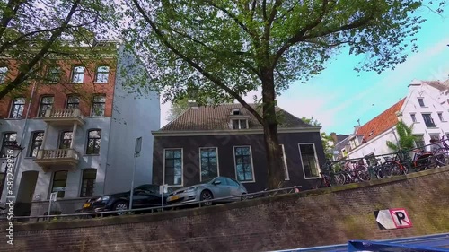 Riding in a boat on a canal along houses in Amsterdam in summer on a sunny day. photo