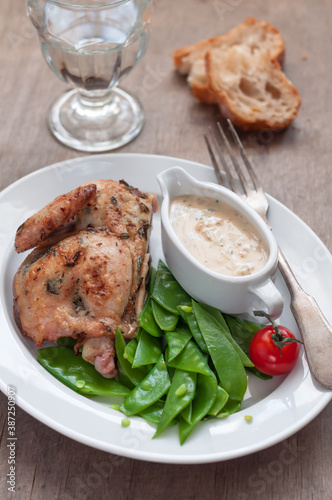 Half Roasted Chicken with Sugar Snap Peas as Side Dish and Cream Sauce