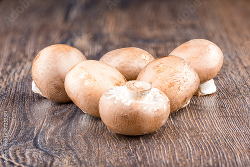 Fresh brown mushrooms champignons on a wooden table.