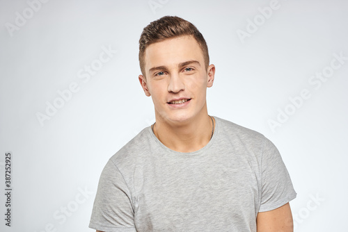 man in gray t-shirt emotions light background cropped view