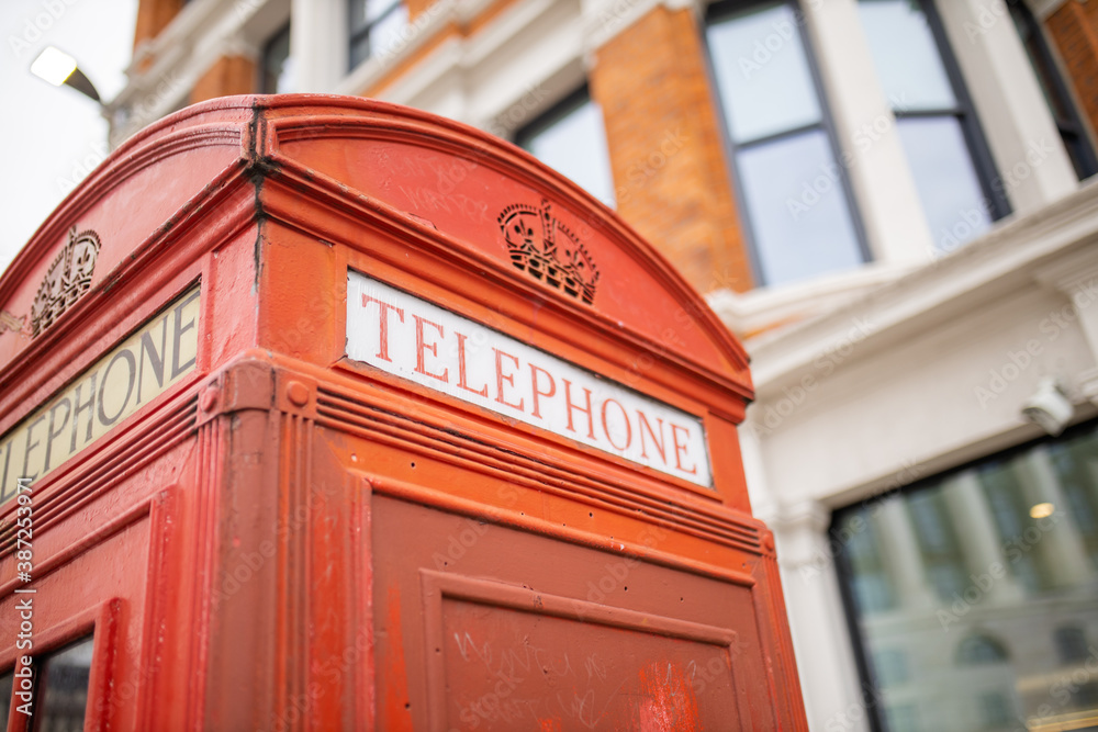 Close up of the top of a London telephone booth and a brick building behind it Close up of the top of a London telephone booth and a brick building behind it