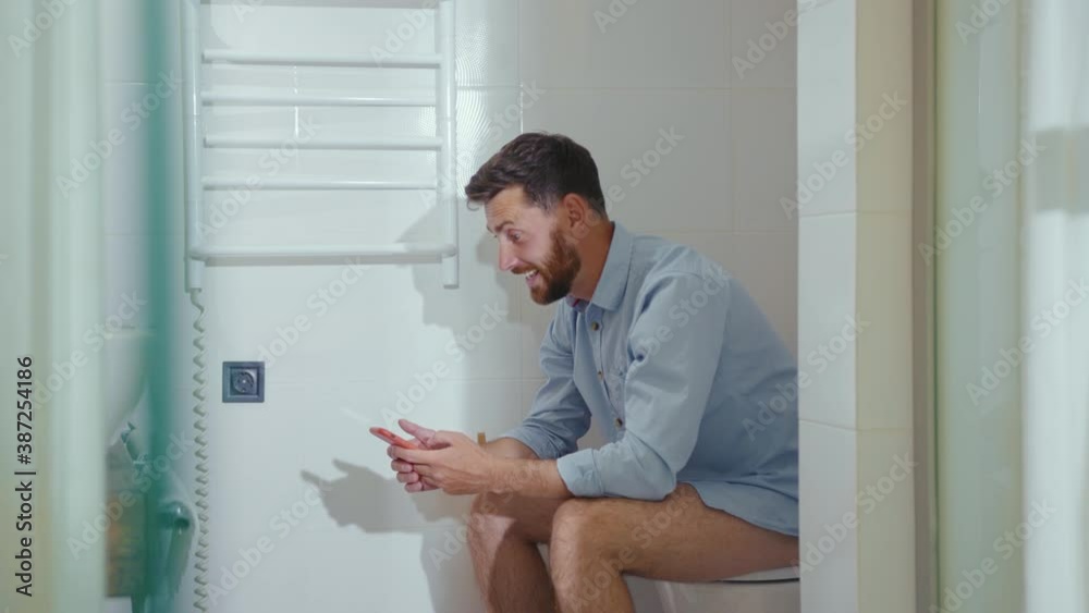 Happy businessman use phone sitting on the toilet smiling mobile restroom. Vlogger influencer around social media, app icons animation loud with white interface. Slow motion