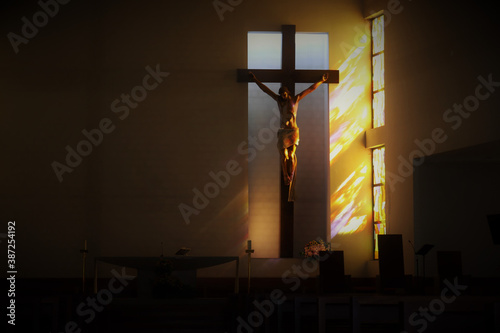 The crucifixion of Jesus on the cross in the temple, illuminated by the sun through the stained glass windows.