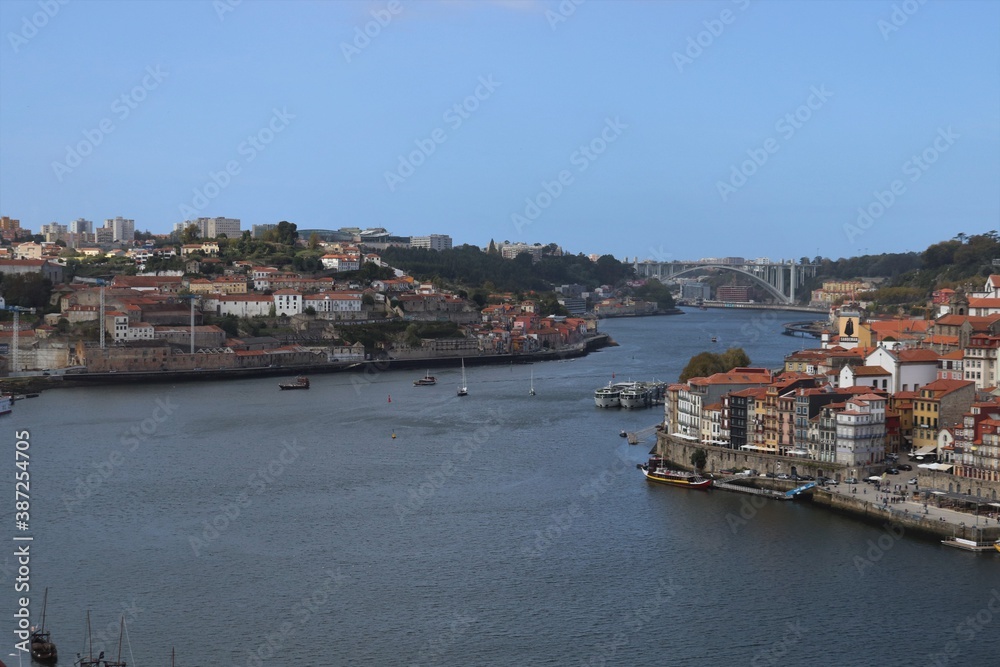 Urban landscape of a European city overlooking the river and houses with red roofs.