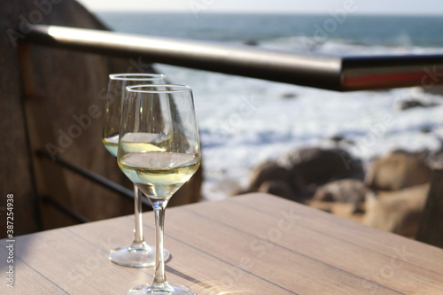 White wine in glasses for two. Romantic still life in a cafe overlooking the ocean.