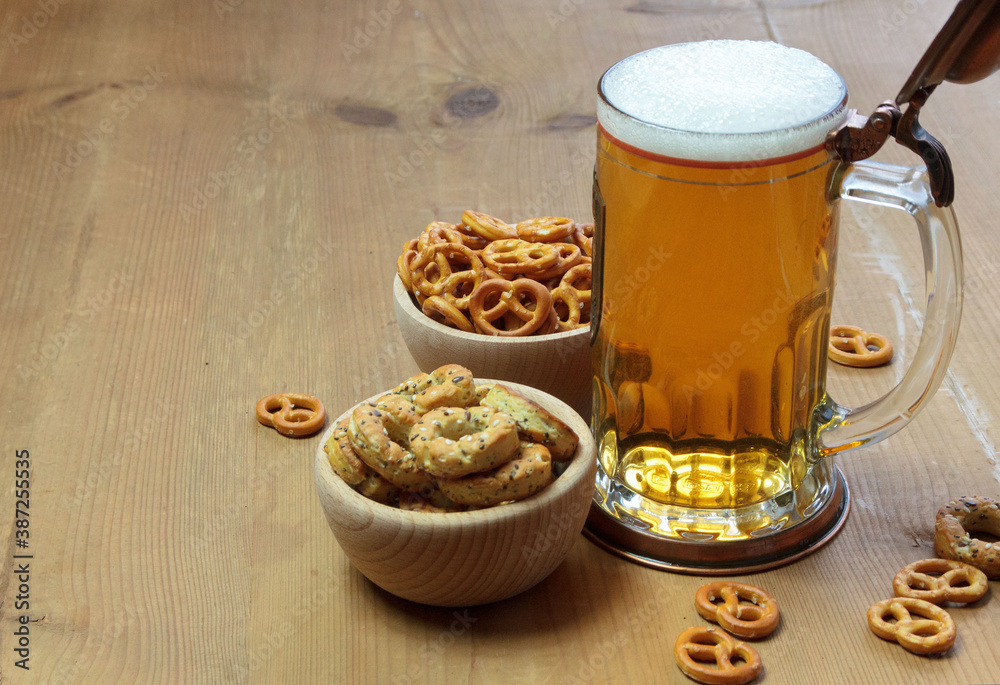 Beer in a mug and pretzels on a wooden background Beer in a mug and pretzels on a wooden background