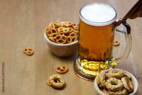 Beer in a mug and pretzels on a wooden background