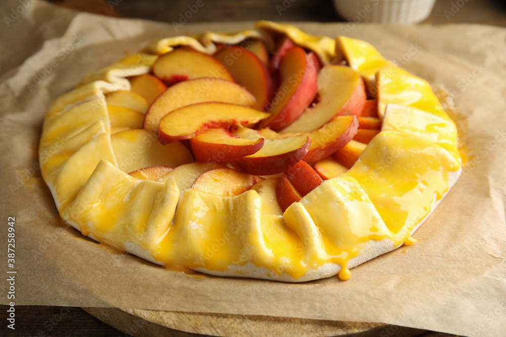 Uncooked peach pie on wooden table, closeup - obrazy, fototapety, plakaty 