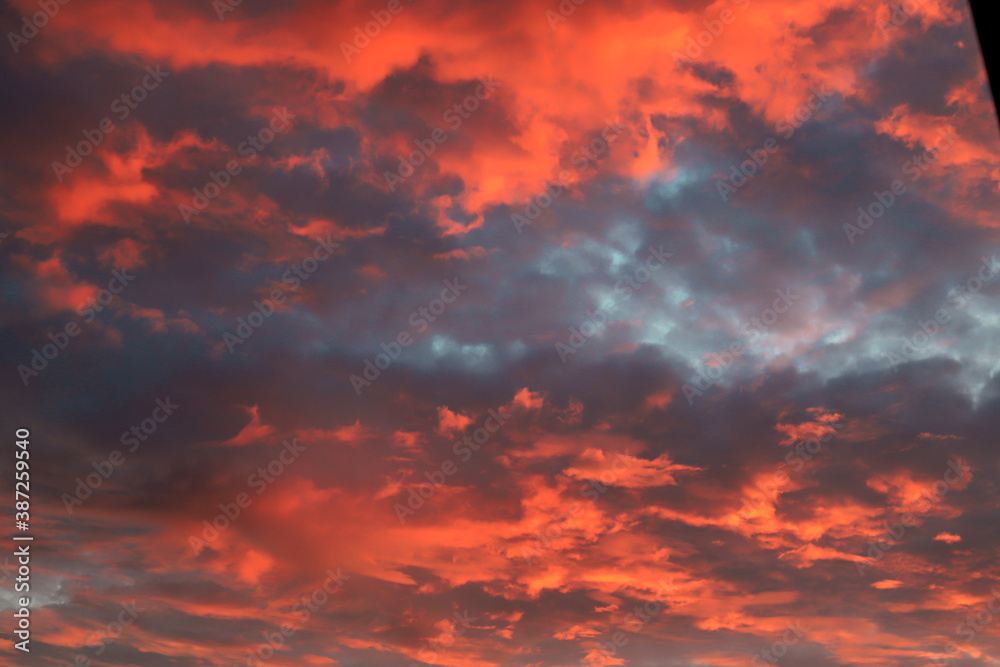 Beautiful red, orange cumulus clouds against a dark sky at sunset in the evening, climate change, global warming. Scenic landscape background, fantasy clouds.