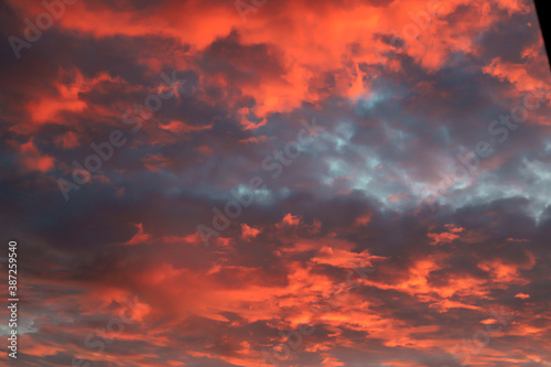 Beautiful red, orange cumulus clouds against a dark sky at sunset in the evening, climate change, global warming. Scenic landscape background, fantasy clouds.