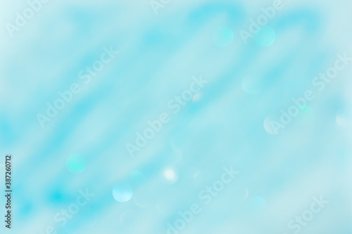 Abstract blue background with bokeh defocused. Fashionable bright turquoise color of sea water. Festive clean blue layout of a postcard, banner for the New year. The concept of the winter holidays.