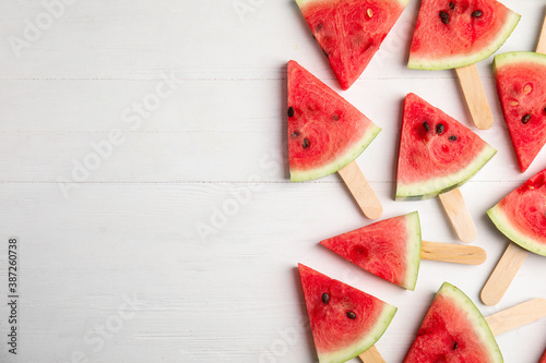 Slices of ripe watermelon on white wooden table, flat lay. Space for text