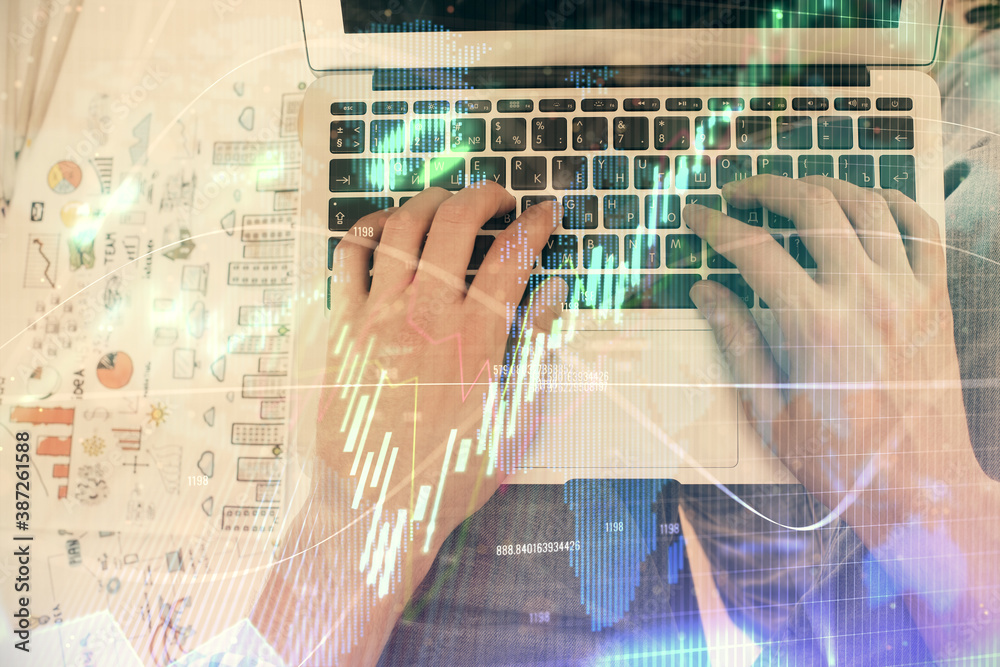 Double exposure of man's hands typing over laptop keyboard and forex chart hologram drawing. Top view. Financial markets concept. Double exposure of man's hands typing over laptop keyboard and forex chart hologram drawing. Top view. Financial markets concept.