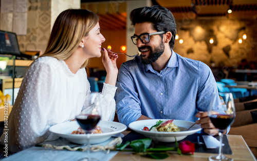 Paste and red wine. Young couple enjoying lunch in the restaurant. Lifestyle, love, relationships, food concept