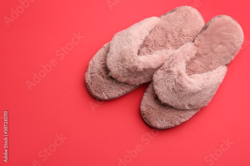 Pair of stylish soft slippers on red background, flat lay. Space for text