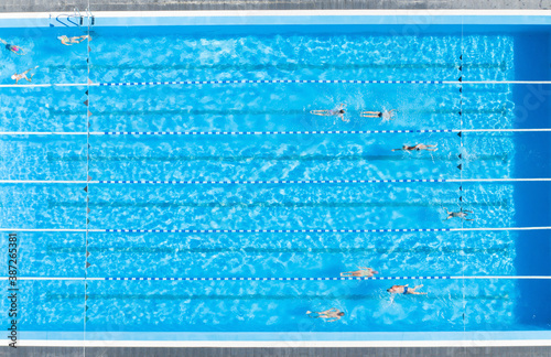 People training in outdoor swimming pool, top view photo