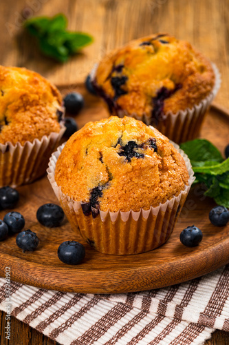 Blueberry Muffins with Fresh Blueberries on Wooden Background. Selective focus.